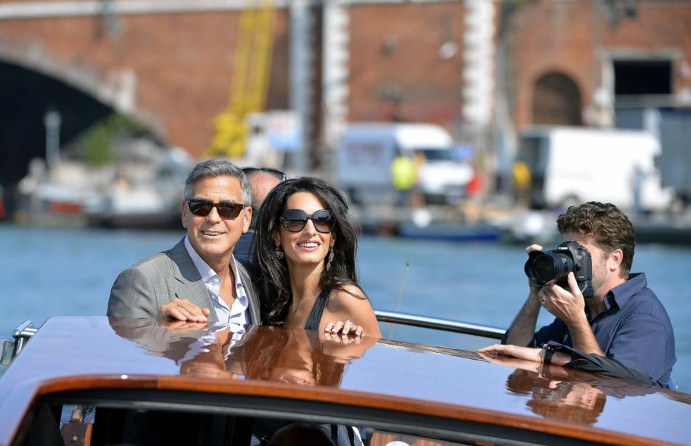 US actor George Clooney ( L) and his Lebanon-born British fiancee Amal Alamuddin take a taxiboat upon their arrival in Venice on September 26, 2014, on the eve of their wedding. AFP PHOTO / ANDREAS SOLAROANDREAS SOLARO/AFP/Getty Images