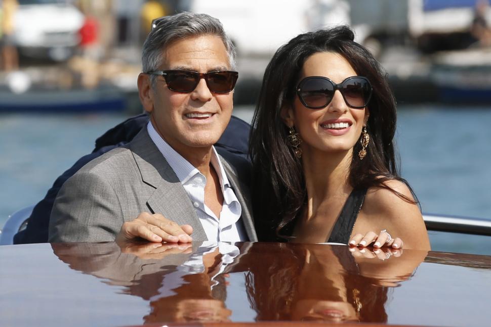 George Clooney, left, and Amal Alamuddin arrive in Venice, Italy, Friday, Sept. 26, 2014. Clooney, 53, and Alamuddin, 36, are expected to get married this weekend in Venice, one of the world’s most romantic settings. (AP Photo/Luca Bruno)