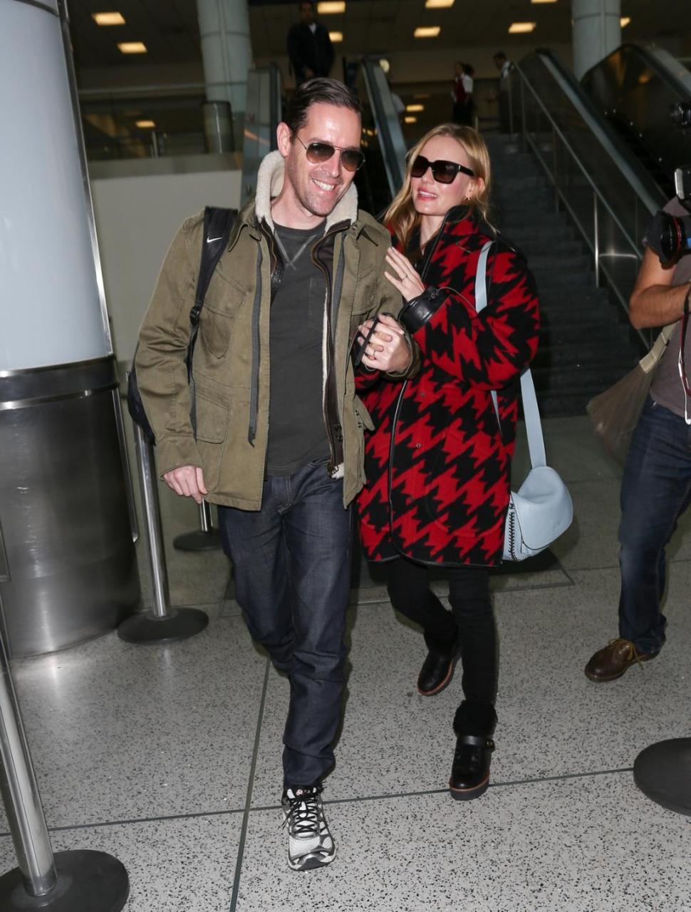 Kate Bosworth and Michael Polish stroll through LAX wearing standard celebrity off-duty looks.