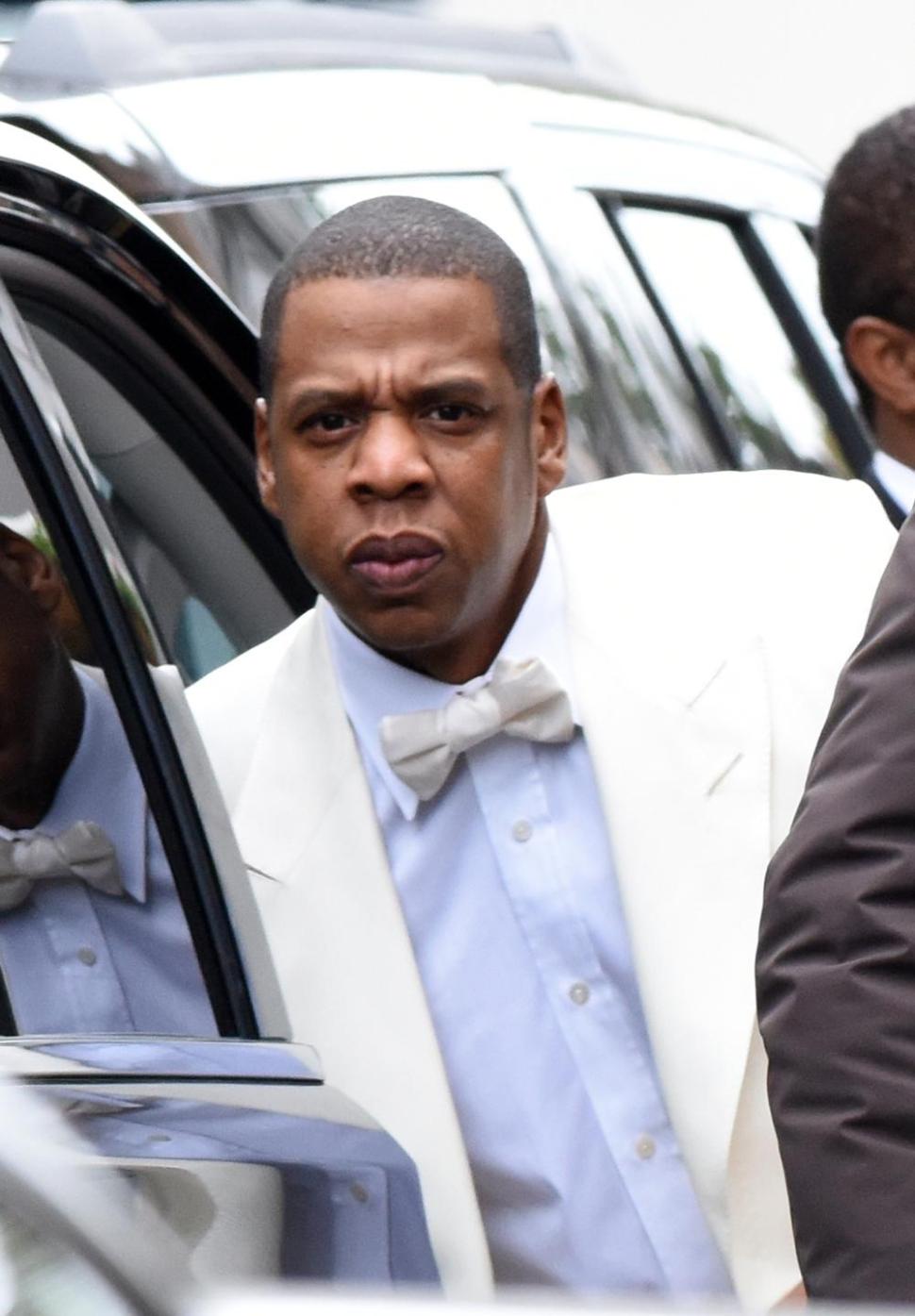 Jay Z arrives for his sister-in-law’s wedding looking suave in his white tuxedo.