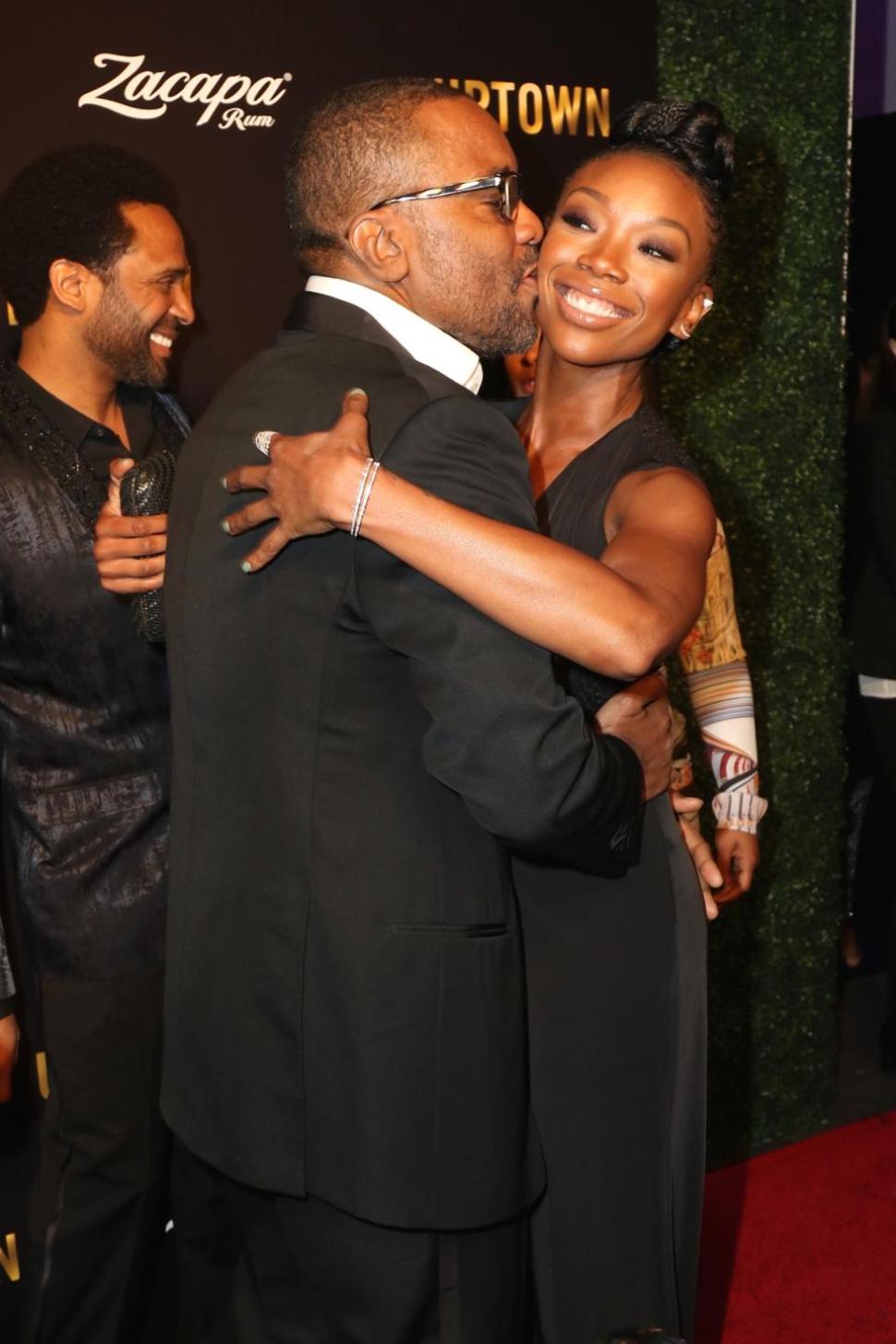 Director Lee Butler gives Brandy a smooch at Uptown mag's pre-Oscars' gala.