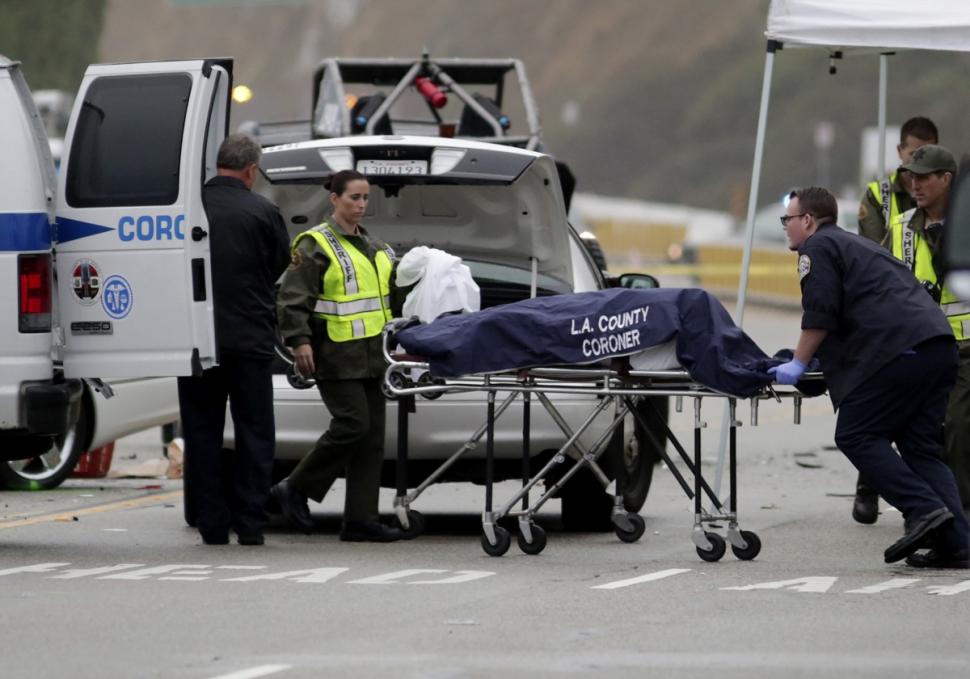 A Los Angeles County coroner worker loads a victim into a van at the scene of a four-car crash involving Bruce Jenner on Feb. 7.