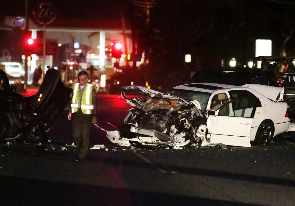 A Los Angeles County Sheriff's Deputy walks past a severely damaged vehicle at the scene of a four-car crash February 7, 2015.