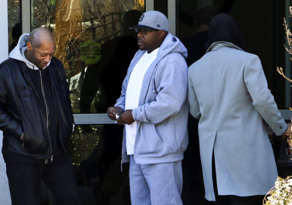 Bobby Brown, center, stands in February outside Emory Hospital in Atlanta where daughter Bobbi Kristina Brown is being treated.