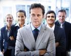 Portrait of a handsome business leader crossing his arms with his team standing behind himThe cast of "Unfinished Business" are featured in a free series of stock images available exclusively at www.iStock.com.Vince Vaughn
