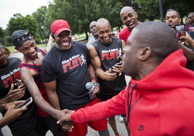 Kevin Hart, right, greets runners as prepares to lead an impromptu 5K run he organized on social media through Piedmont Park Friday in Atlanta.
