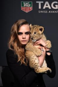 Model Cara Delevingne poses with a baby lion as she joins TAG Heuer as Brand Ambassador.