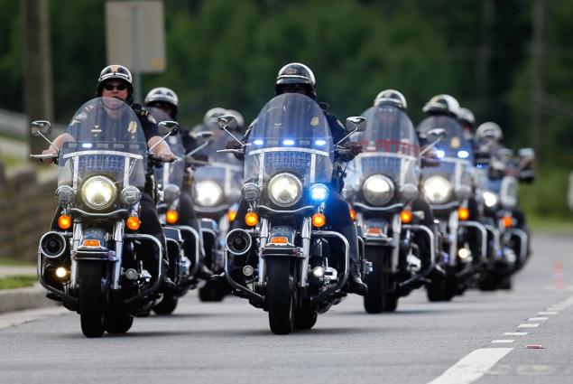 A police motorcycle procession escorts guests to the memorial service for Bobbi Kristina Brown at St. James United Methodist Church on Saturday.